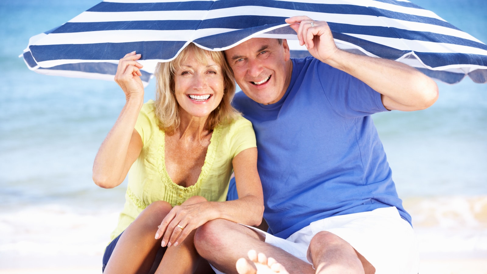 happy older couple sheltering from sun