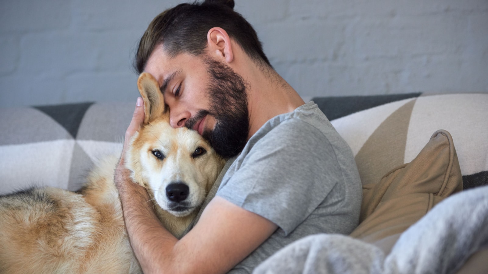 man cuddling dog